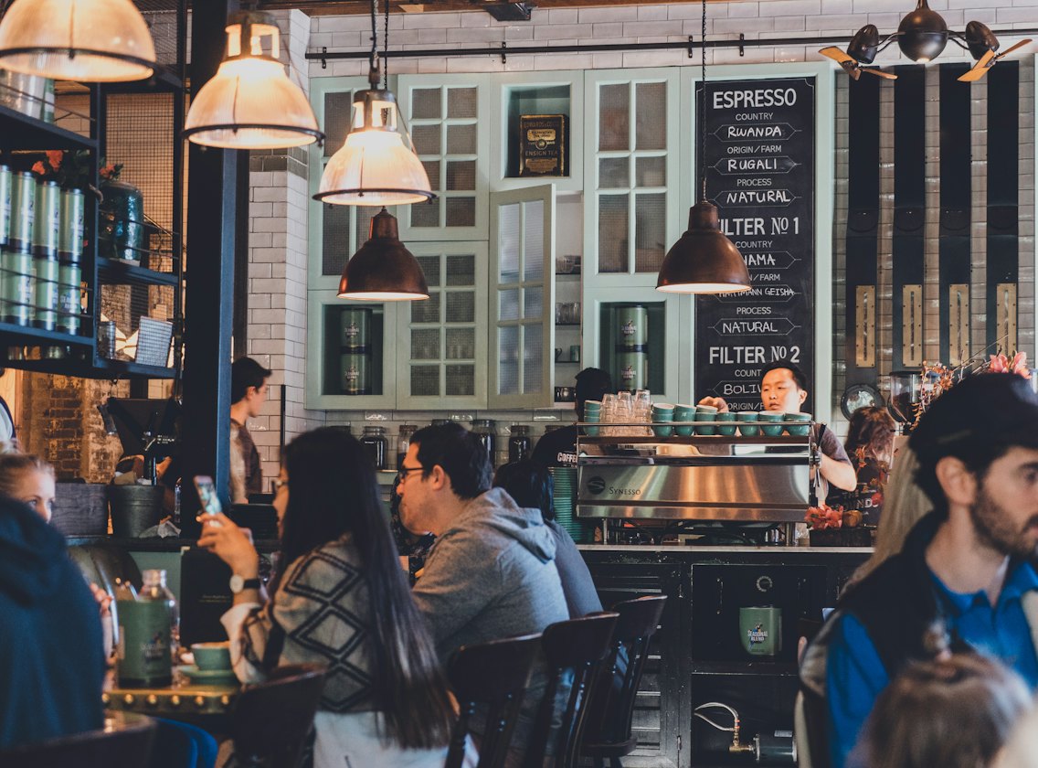 A warmly lit café where guests are chatting